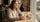 Woman at café with afternoon coffee and watch considering caffeine cutoff time for better sleep