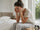 Woman sitting up in bed with a mild morning headache after poor sleep, illustrating the connection between sleep quality and headaches.