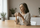 Tired person sitting at a table with a cup of coffee, showing low energy despite drinking caffeine.