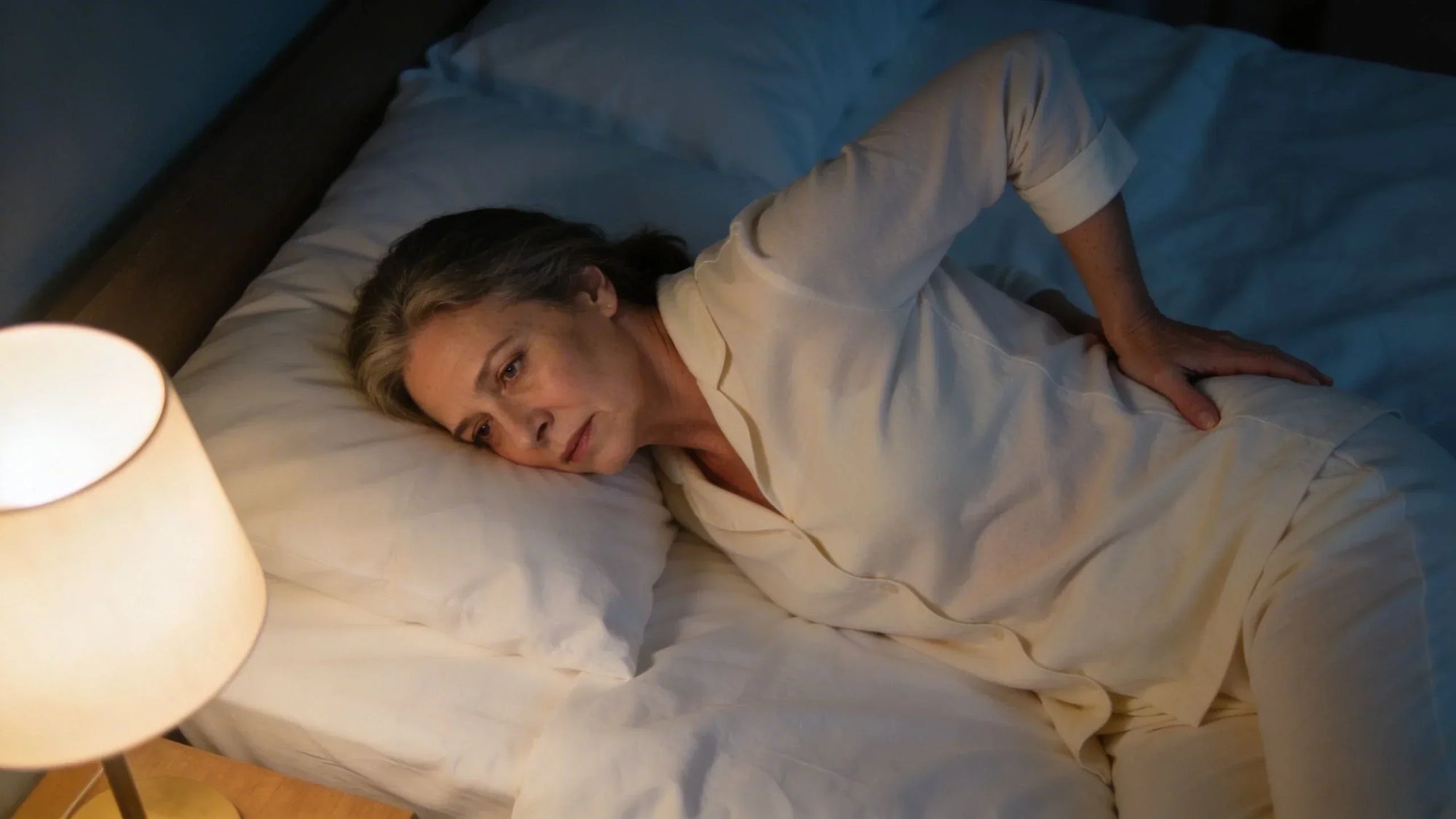 Woman in bed finding comfortable sleeping position for lower back pain relief