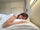 Woman sleeping peacefully with Vitalisys Sleep Patch on upper arm in natural bedroom light