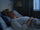 Woman in her 50s lying awake in bed in the early morning with faint predawn light coming through the window, unable to fall back asleep