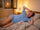 Woman over 50 lying awake on hot summer night with electric fan and open window struggling to sleep without air conditioning