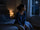 Woman sitting on the edge of her bed at night looking out the window, illustrating nighttime anxiety and difficulty relaxing before sleep.